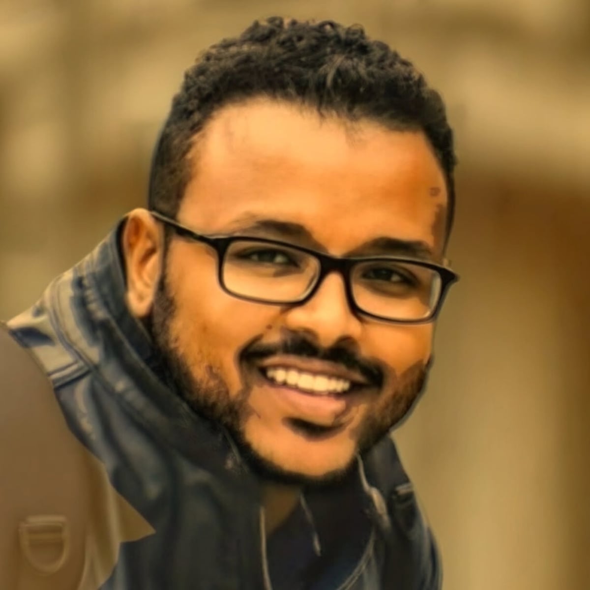 Portrait of Abdulrahman Awadallah smiling and wearing black glasses.