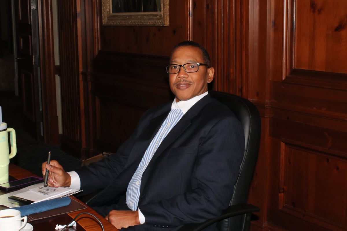 Attorney Terance Madden, founder of T. Madden & Associates, P.C., seated at a conference table in a wood-paneled office.