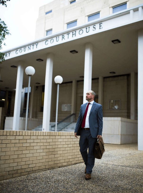 Justin Fowles, a Conroe DWI lawyer, walking outside the Montgomery County Courthouse carrying a briefcase.