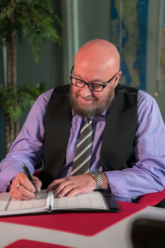 Estate planning attorney Dan Powell writing in a planner at his desk