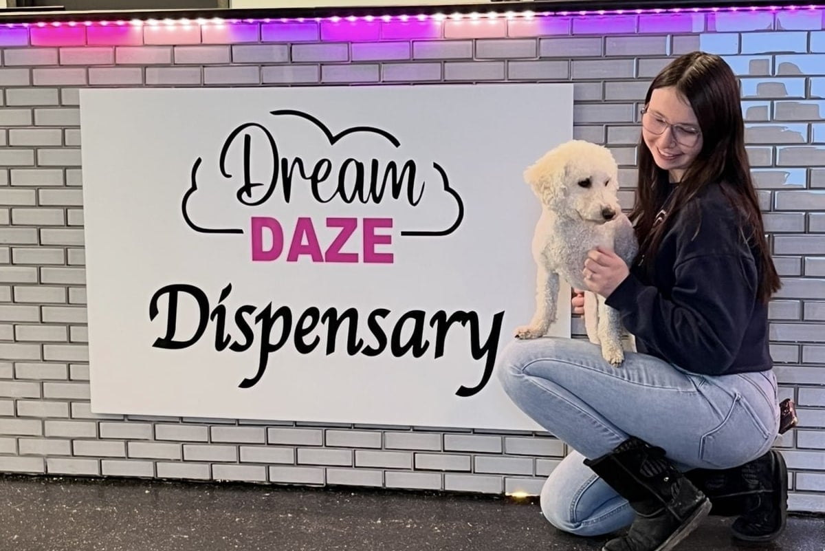 Dream Daze Dispensary in Depew, NY Hosts Awesome Paws Rescue Adoption Event on September 25 A Dream Daze Dispensary team member holds a rescue dog beside the Dream Daze Dispensary sign in Depew, New York