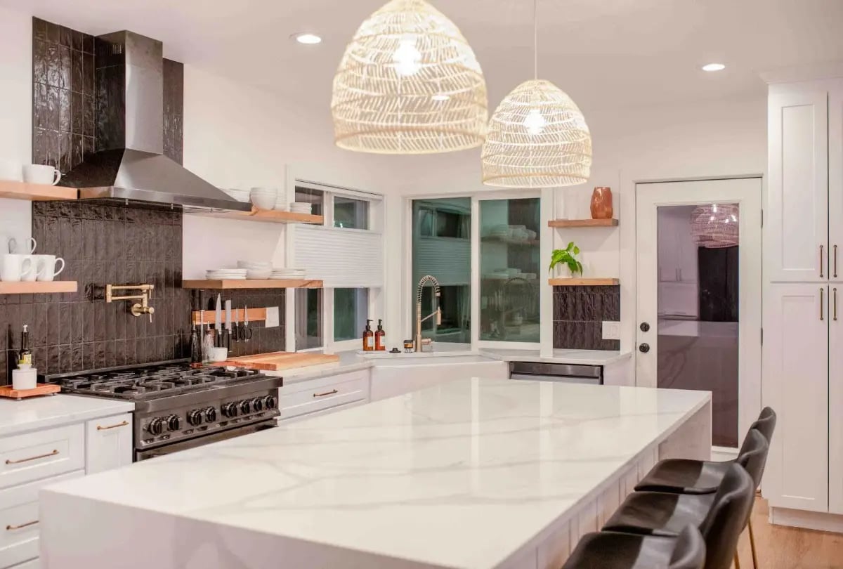Full home remodel featuring a bright modern kitchen with white cabinetry and a large island.