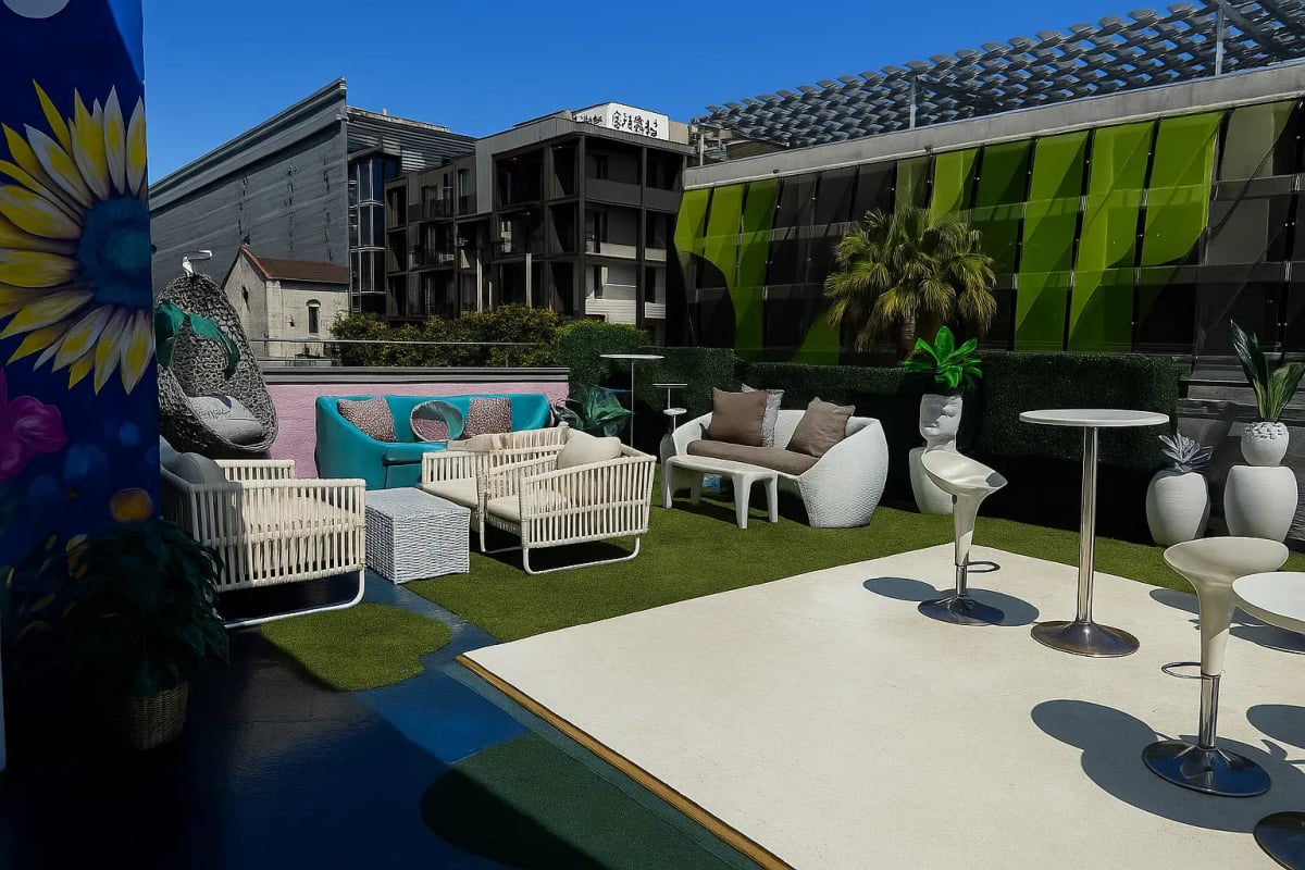 Rooftop event venue at The Kult LA in Downtown Los Angeles with colorful lounge seating, cocktail tables, greenery.